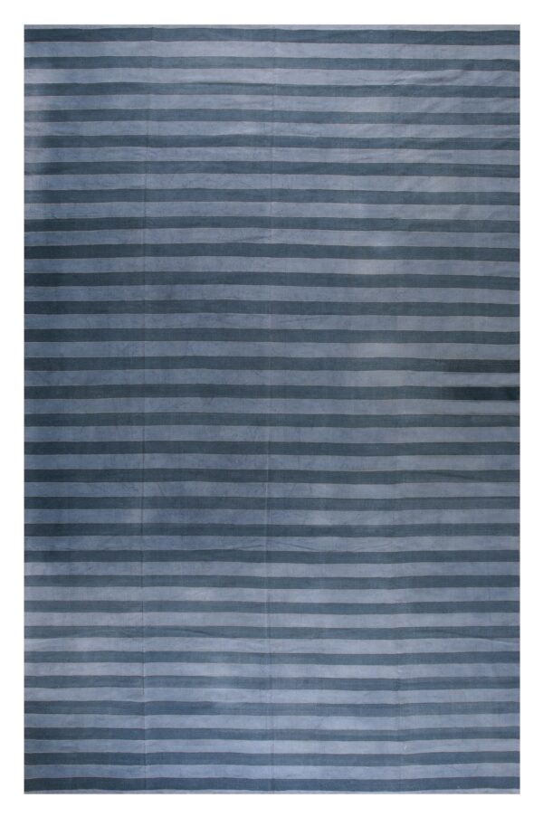 Textured low pile rug with wide horizontal stripes in alternating dark and light blue shades.