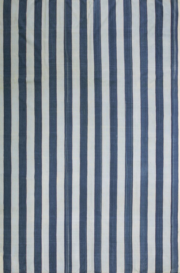 Low-pile textile displays alternating vertical stripes in deep indigo and pale off-white.