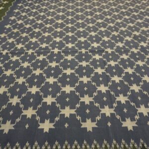 Flatweave rug in blue and cream with a geometric pattern and an adjoining olive green border.
