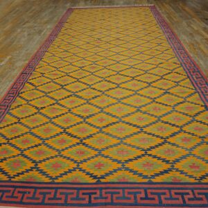 Yellow flatweave runner with diamond and Greek key patterns rests on light hardwood floors.