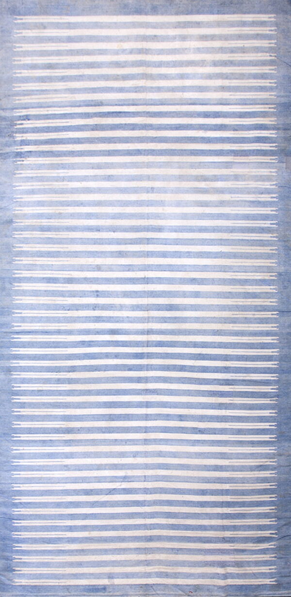 Faded blue and white rug with vertical stripes and small decorative dash motifs at both ends.