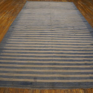Blue and tan flatweave rug with irregular horizontal stripes resting on hardwood flooring.