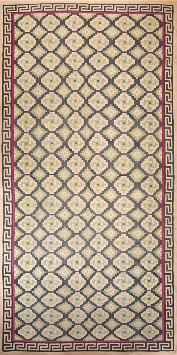 Low-pile runner rug with repeating beige, green, and dark blue geometric diamonds framed by a greek key border.