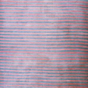 The rug features vertical stripes of faded pink and muted blue across a low-pile surface.