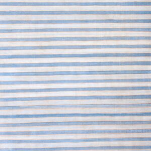 Flatweave rug with alternating blue-gray and beige vertical stripes on a worn hardwood floor.