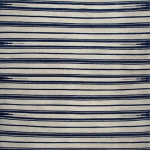 Striped flatweave rug in cream and deep blue displayed on rustic wooden floorboards.