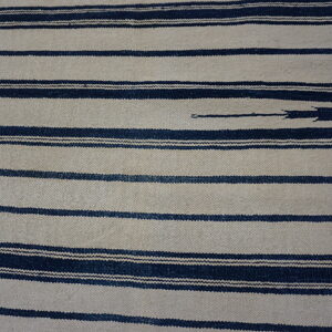 Textured flatweave rug with wide beige stripes alternating with thinner, dark indigo horizontal bands.