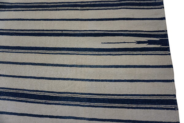 Textured flatweave rug with wide beige stripes alternating with thinner, dark indigo horizontal bands.