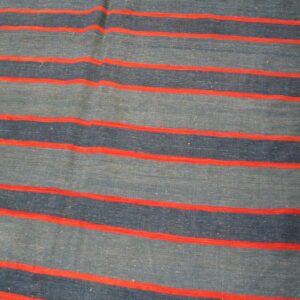 Flatweave rug featuring wide blue and dark blue stripes separated by thin red accent lines on a wood floor.