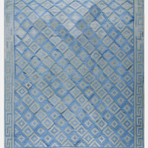 Blue rug with light tan geometric diamonds, prominent color variation, and a Greek key patterned border.