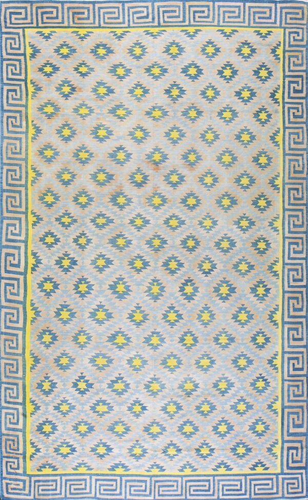 Blue and yellow geometric rug featuring stepped diamond motifs and a wide greek key border design.