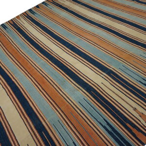Low-pile rug with alternating vertical stripes of navy, terracotta, cream, and light blue.