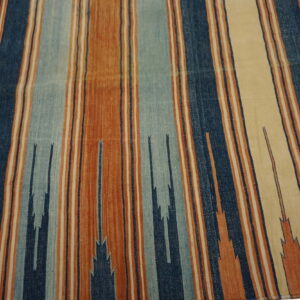 Rust, cream, and blue striped flatweave rug with subtle zigzag geometric elements.