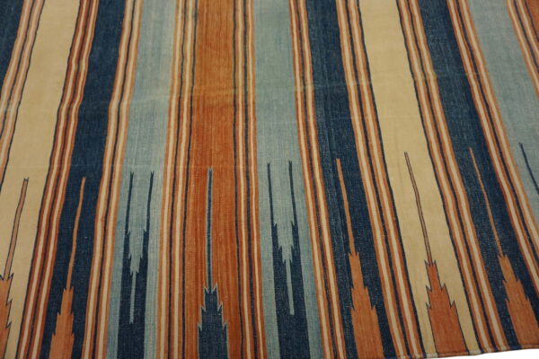 Rust, cream, and blue striped flatweave rug with subtle zigzag geometric elements.