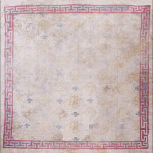Distressed cream rug with a geometric faded yellow and blue field pattern and a bold red Greek key border.