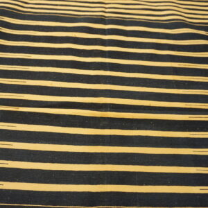 Flatwoven rug with thick, irregular dark blue and cream horizontal stripes on wood planks.