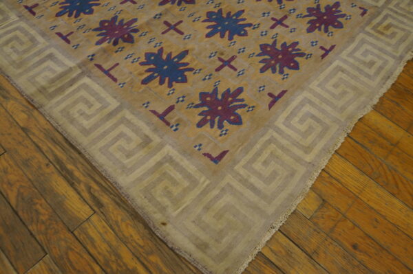 Antique dhurrie small scatter size cotton brown rug 6 Gold and beige geometric rug featuring blue and purple designs rests on rustic wooden planks.