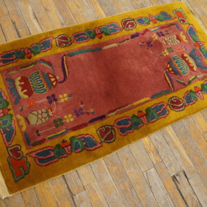 A colorful rug featuring a red field and yellow border rests on rustic wooden floorboards.