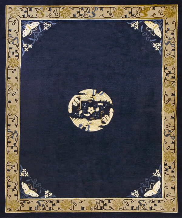 Navy rug with a central gold bird medallion and a detailed beige border with floral and butterfly motifs.