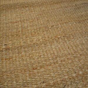 Natural beige rug featuring a heavy looped texture, visible next to wood floorboards.