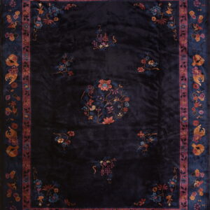 A deep navy rug with high sheen, featuring multi-colored floral patterns and wide decorative borders.