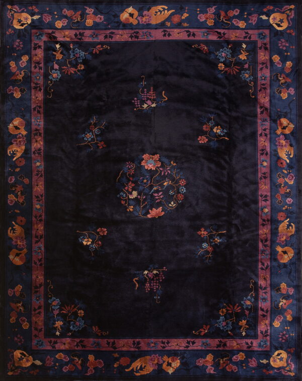 A deep navy rug with high sheen, featuring multi-colored floral patterns and wide decorative borders.