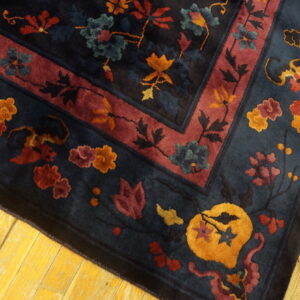 High-pile rug with navy, red, gold, and teal floral patterns, resting on bright yellow wood flooring.