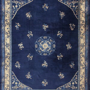Deep blue traditional rug with a central medallion, scattered light floral sprays, and a contrasting cream border.