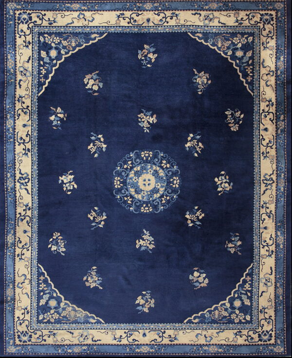 Deep blue traditional rug with a central medallion, scattered light floral sprays, and a contrasting cream border.