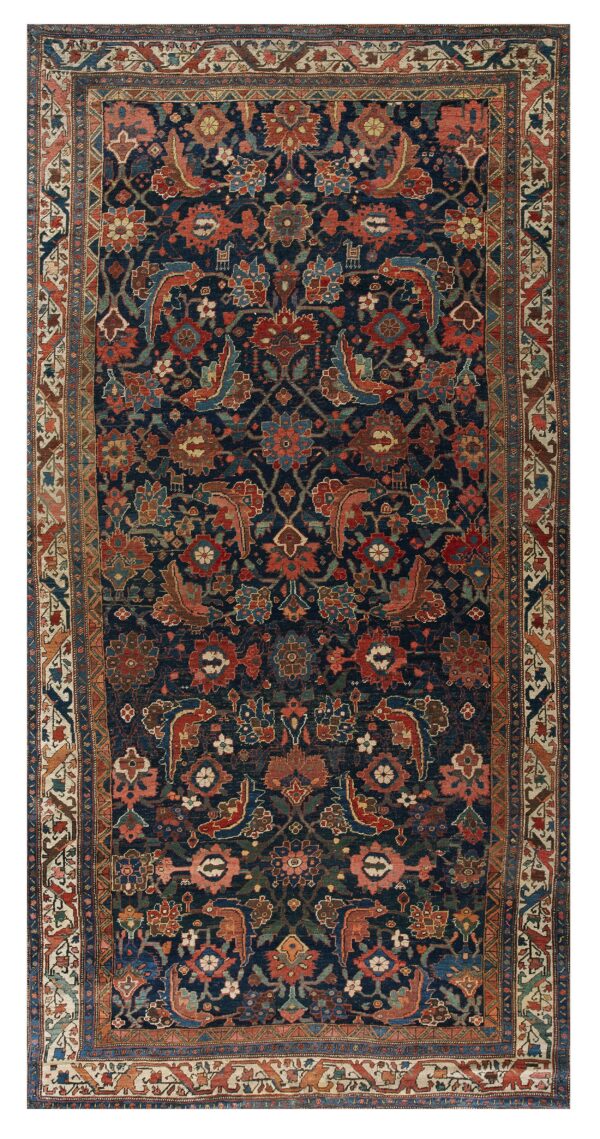 Navy blue area rug featuring an intricate red, pink, and tan floral and stylized animal design.