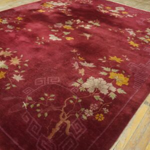 Deep burgundy rug featuring botanical designs in muted yellow, gray, and green on light wood floors.