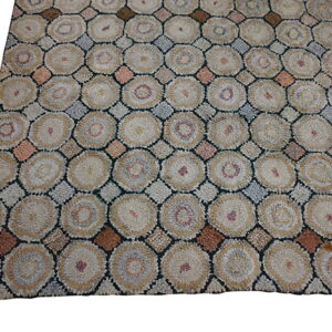 Textured rug pattern of beige and tan circles separated by gray, brown, and rust diamond shapes.
