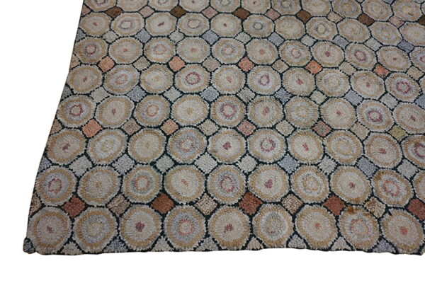 Textured rug pattern of beige and tan circles separated by gray, brown, and rust diamond shapes.