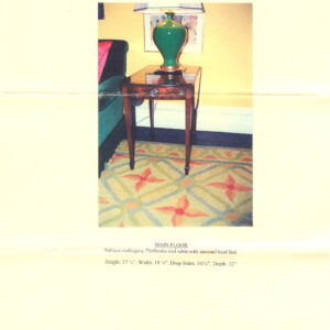 Low-pile rug featuring orange florals and light green lattice pattern under a dark wood end table.