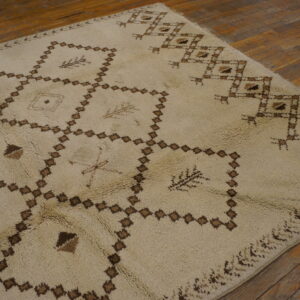 Shaggy cream rug featuring brown interlocking diamond patterns on distressed wood flooring.