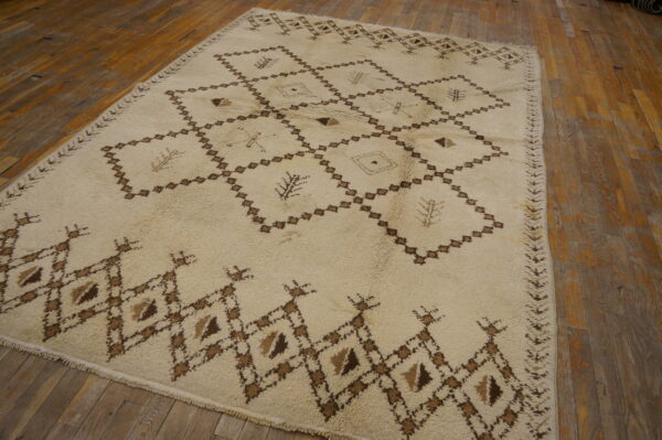 High-pile ivory rug with a dark brown diamond lattice design covers rustic wood plank flooring.