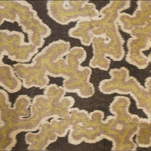 Textured rug displays abstract, feathered shapes in tan, olive green, and cream on dark brown.