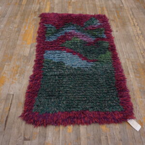 High-pile shaggy rug with magenta border and abstract green and blue pattern on distressed wood planks.