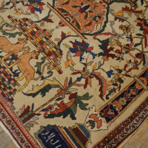 Beige rug featuring complex multicolored floral and stylized animal motifs rests on weathered wood planks.