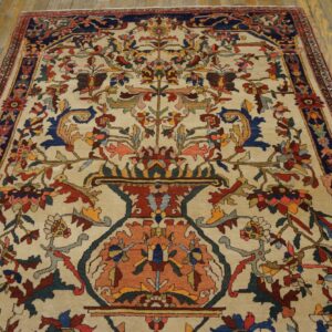 Cream rug with a traditional multi-color floral vase pattern over distressed wood planks.