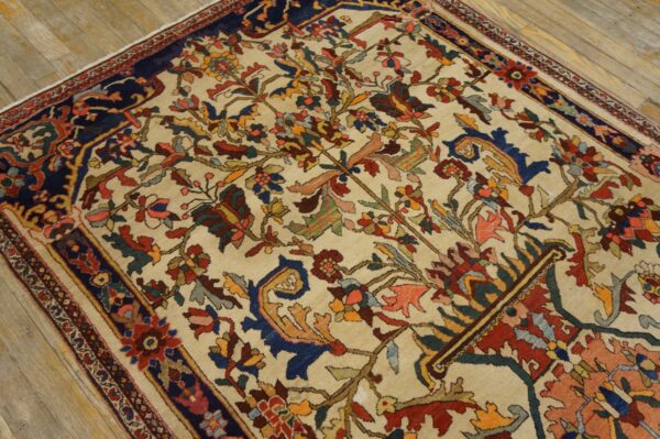 Traditional rug with a multicolored floral design on a cream field and dark blue border, placed on wood floors.