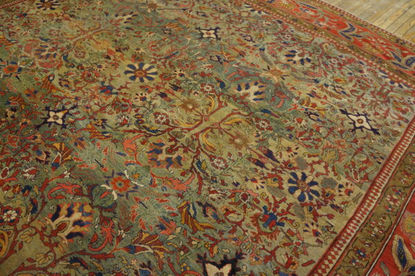 Low-pile rug with a dense green, red, and blue floral pattern visible on wooden flooring.