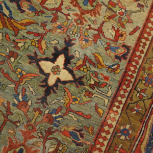 Close-up of a low-pile rug with a teal field, complex red and blue floral patterns, and multi-banded border.