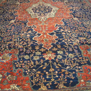 Traditional high-pile rug featuring a central medallion and intricate patterns in navy blue, brick red, and cream.