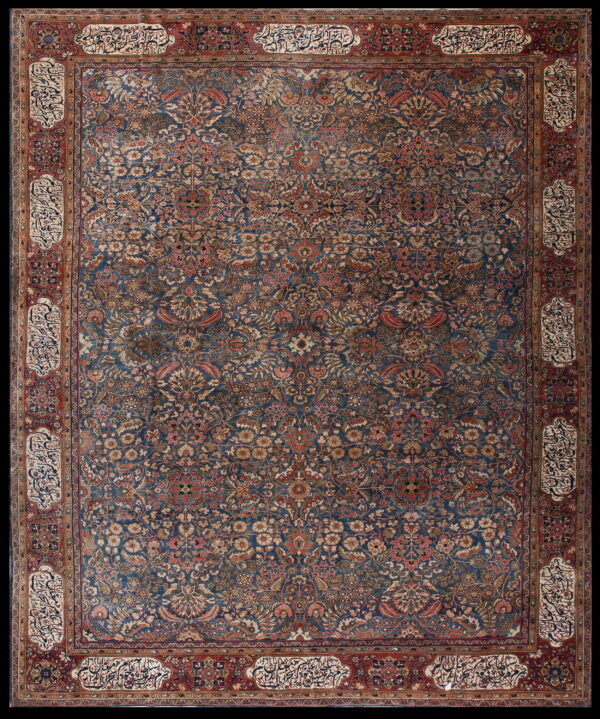 Dark blue rug with a dense all-over floral pattern, framed by a red border with calligraphy cartouches.