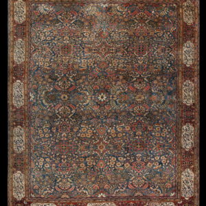 Intricate blue rug with dense red and gold floral motifs and an elaborate border containing calligraphic panels.