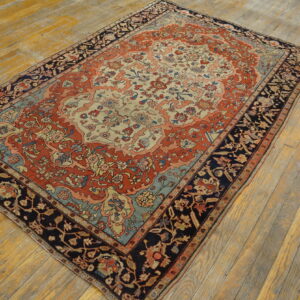 Terracotta, ivory, and navy traditional rug with a floral medallion pattern resting on distressed wood planks.