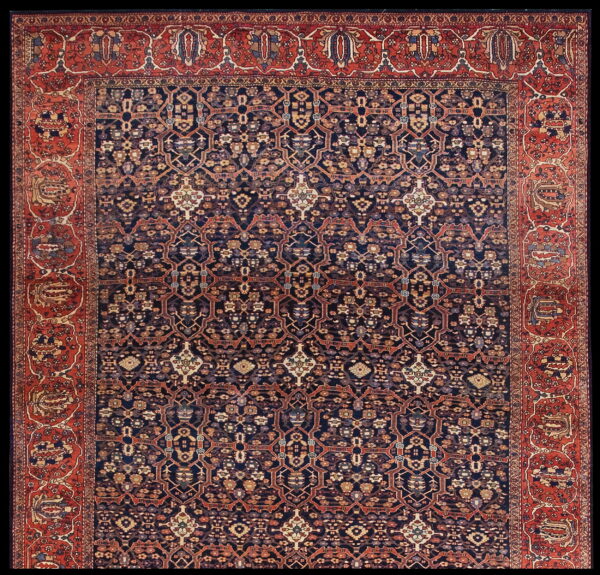 Intricate, low-pile traditional rug featuring a dark indigo geometric lattice and wide brick-red ornamental borders.