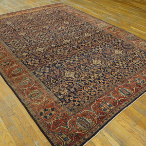 Traditional navy blue and rust area rug with an all-over intricate pattern on light wood floors.