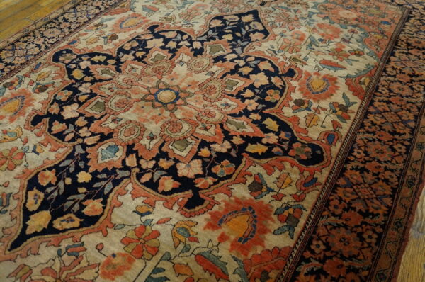 Ornate traditional rug in navy, terracotta, and cream with a detailed floral design on hardwood floors.